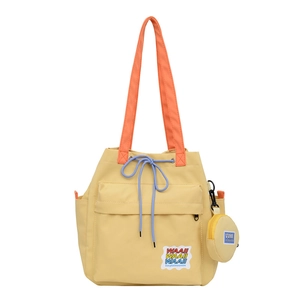 Canvas bucket tote bag with orange straps and drawstring closure in yellow color