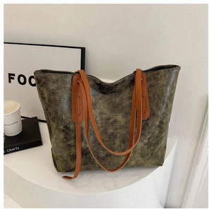 Detail of olive green marbled texture tote bag with brown handles on white display stand
