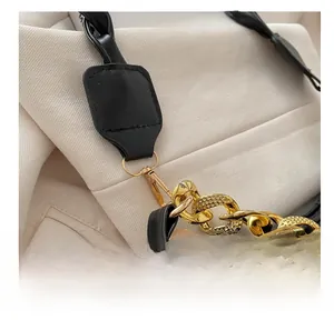Close-up of quilted black leather bag with premium gold chain and metal swivel hook