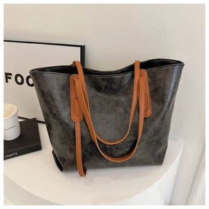 Detail of vintage oil wax leather tote bag showing textured grey finish and brown strap