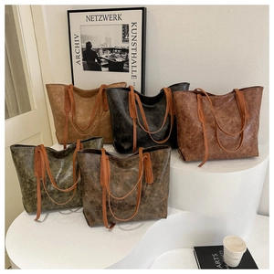 Minimalist vintage faux leather tote bags in five colors on modern white stairs