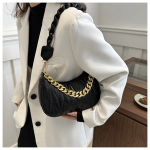 Close-up of quilted black leather hobo bag with gold chain and wide shoulder strap