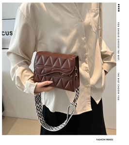 Dettaglio borsa a tracolla marrone con cuciture geometriche e ampia tracolla alla moda