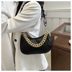 Detail of black quilted leather crescent bag with thick gold chain and woven strap