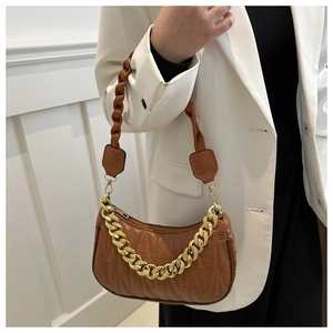 Detailed side view of a brown quilted baguette bag with gold chain and braided strap