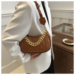 Close-up of brown quilted hobo bag with a gold chain and woven leather shoulder strap