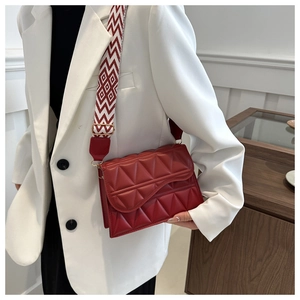 Dettaglio borsa a tracolla rossa trapuntata con ampia tracolla a motivi geometrici alla moda