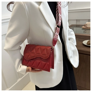 Dettaglio della borsa a tracolla rosso scuro con trapuntatura e ampia tracolla in tessuto