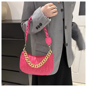 Detail of bright pink quilted half-moon bag with gold chain and woven shoulder strap
