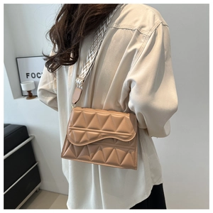 Modella con borsa a tracolla trapuntata kaki e ampia tracolla in tessuto decorata