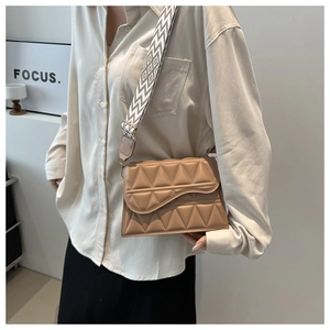 Dettaglio borsa color cammello con motivi geometrici e tracolla larga tessuta