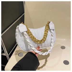 Detail of white quilted hobo bag with gold chain and woven strap held by a hand