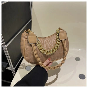 Detail of khaki quilted baguette bag featuring chunky gold chain and woven shoulder strap