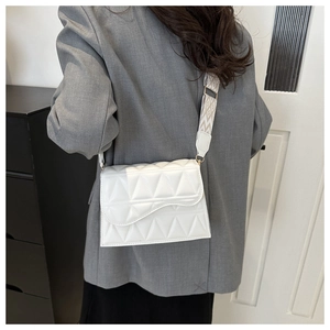 Borsa quadrata trapuntata bianca con tracolla jacquard indossata da modella in interno