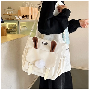 Close-up of white nylon crossbody bag with cute bunny ears and fashion label on flap