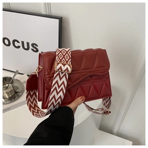 Dettaglio borsa a tracolla bordeaux con trapuntatura geometrica e tracolla larga