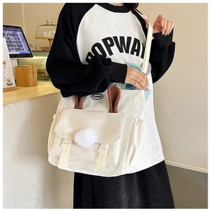 Detail of white nylon crossbody bag featuring cute rabbit ears and plush pompom accents