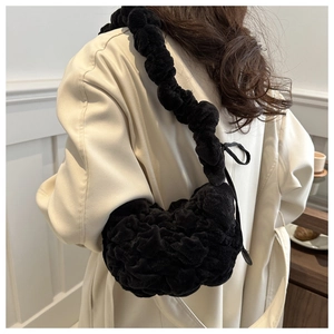 Detail of black plush pleated shoulder bag showing soft ruffled texture and thick strap