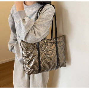 Quilted metallic bronze tote bag with geometric padding and black shoulder straps