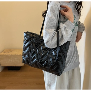 Close-up of quilted black down tote bag on model for casual everyday style