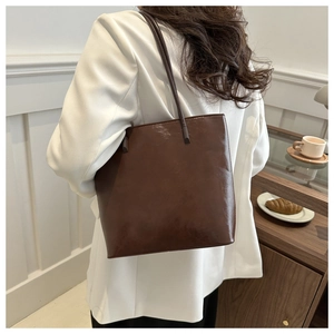 Brown PU leather tote bag shown on shoulder with minimalist business casual outfit
