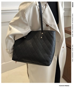 Detail of black quilted PU leather tote bag with metallic studs and fine stitching