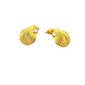 Golden shell earrings with radiant texture and bright cubic zirconia on white background