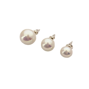 Three sizes of round luster pearl stud earrings set with metallic pins on white background