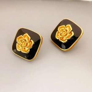 Retro square black enamel camellia earrings with gold metal accents in a 45-degree view