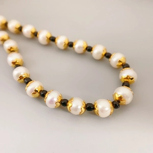 Elegant freshwater pearl necklace with gold flower caps and black spacer beads