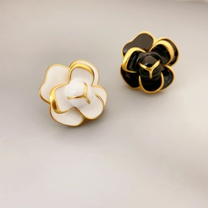 Élégantes boucles d'oreilles camélia émaillées à trois couches en noir et blanc bordées d'or