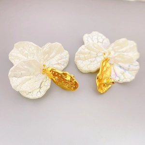 White resin flower stud earrings with gold metal details and 925 silver needles
