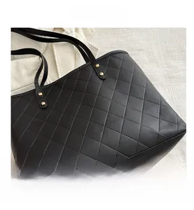 Close-up of black quilted leather tote bag with elegant gold rivet details and premium texture