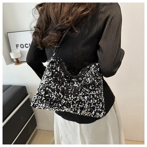 Détail d'un sac à bandoulière à paillettes avec texture scintillante et bandoulière noire