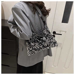 Vue détaillée des paillettes scintillantes noires, blanches et argentées sur le sac à main