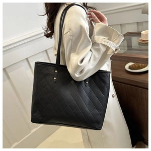 Detail of black quilted tote bag with golden rivets and premium faux leather texture