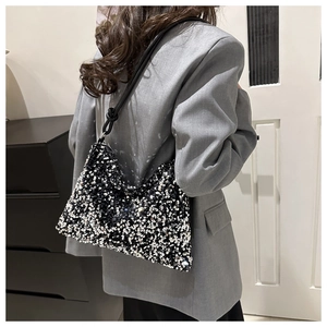 Détail de paillettes noires et argentées scintillantes sur un sac à bandoulière chic