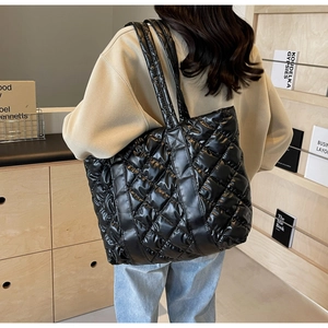 Vue latérale arrière d'un grand sac fourre-tout matelassé noir porté par un mannequin