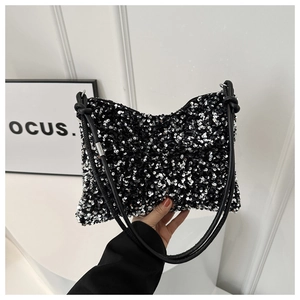 Détail des paillettes noires et argentées et de la bandoulière nouée en cuir du sac