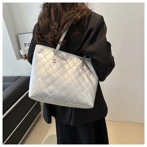 Detail of silver-grey quilted tote bag with diamond stitching and long shoulder strap