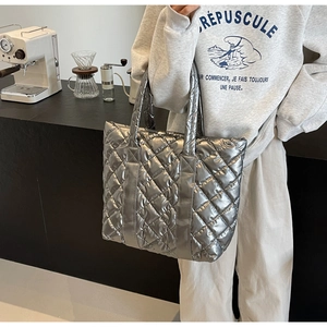 Détail du sac cabas matelassé argenté avec motif de losanges dans un décor moderne