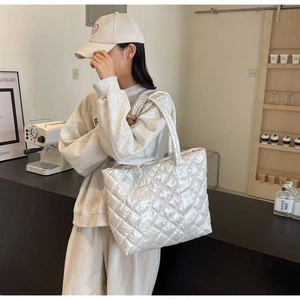 Détail d'un grand sac cabas matelassé beige avec une texture rembourrée et douce