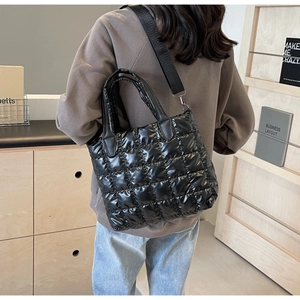 Vue latérale détaillée du sac fourre-tout noir matelassé avec large bandoulière