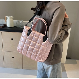 Pink quilted tote bag with glossy nylon finish shown in a stylish casual lifestyle scene