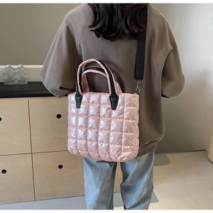 Détail du sac cabas matelassé rose en satin brillant avec des lanières noires
