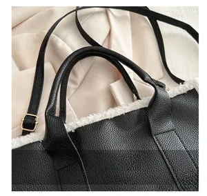 Detail of black pebbled leather tote with white faux fur trim and golden hardware