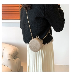 Close-up of champagne gold sequin crossbody evening bag with a gold chain strap