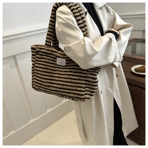 Detail of striped faux shearling tote bag showing plush texture and brand label