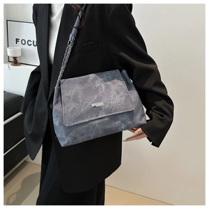 Close-up of marble pattern PU leather texture and silver chain strap on a tote bag