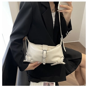 Close-up of cream white PU leather bag featuring silver metal buckle straps and punk hardware